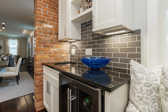 kitchen featuring dark hardwood / wood-style flooring, dark stone counters, sink, white cabinets, and wine cooler