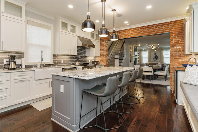 kitchen featuring dark hardwood / wood-style floors, a center island, white cabinetry, and range hood