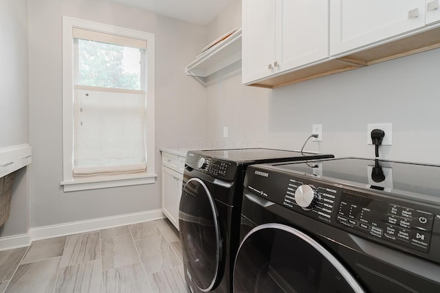 laundry room featuring cabinets and washer and clothes dryer