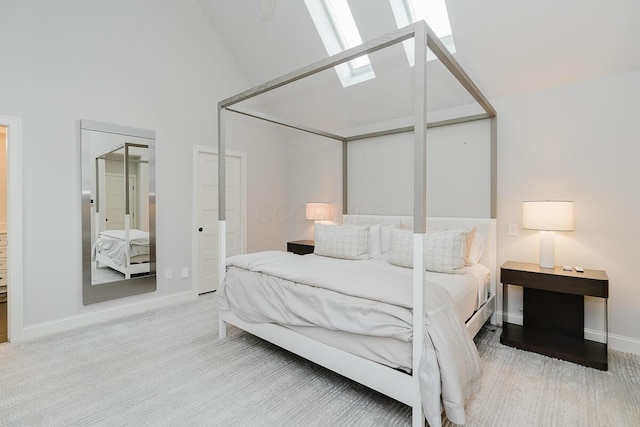 bedroom featuring carpet floors, a skylight, and high vaulted ceiling