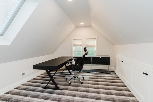 carpeted home office with lofted ceiling