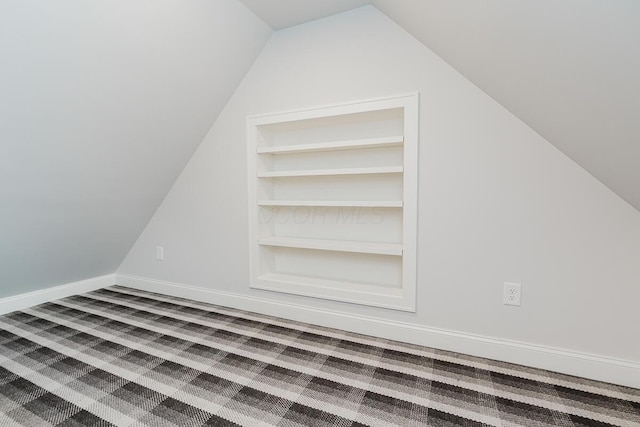 bonus room with built in features, carpet flooring, and vaulted ceiling