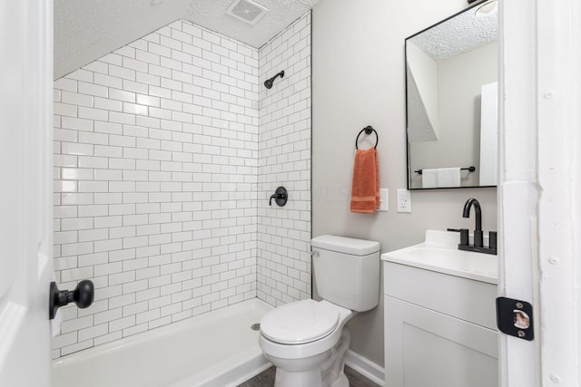 bathroom featuring a tile shower, vanity, a textured ceiling, vaulted ceiling, and toilet