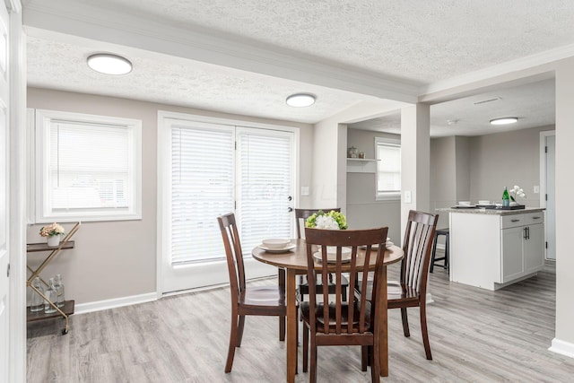 2789 Berrell Ave, Columbus, OH 43211 - dining room featuring a textured ceiling, light wood-style floors, plenty of natural light, and crown molding