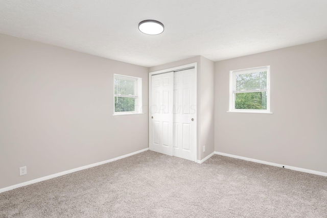 unfurnished bedroom featuring carpet and a closet