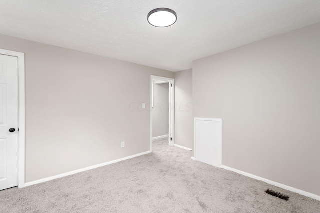 carpeted spare room with a textured ceiling