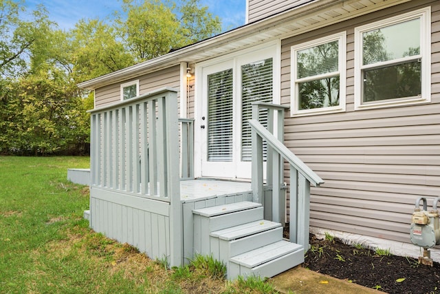 view of exterior entry featuring a lawn