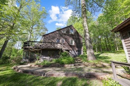 back of property featuring a yard and a deck