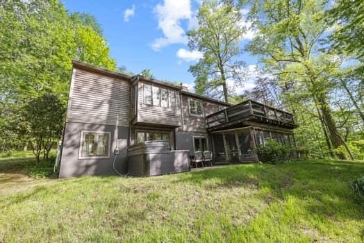 rear view of property with a lawn and a sunroom