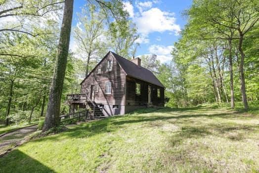 view of side of home featuring a yard and a wooden deck