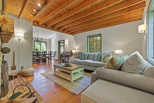 living room with beamed ceiling, wood ceiling, and hardwood / wood-style floors