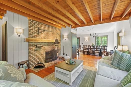 living room featuring beamed ceiling, wooden ceiling, a fireplace, and hardwood / wood-style flooring