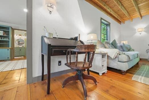 living area with beam ceiling, wood-type flooring, and wood ceiling