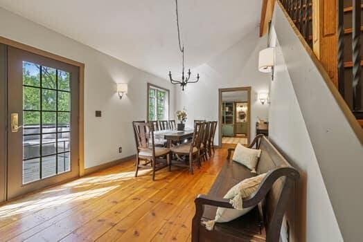 dining space with lofted ceiling with beams, light hardwood / wood-style flooring, and a chandelier