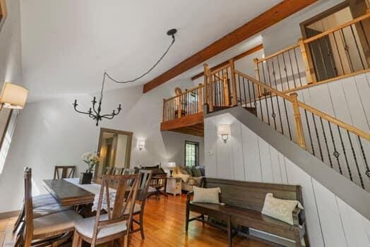 dining area featuring a chandelier, hardwood / wood-style floors, and beamed ceiling