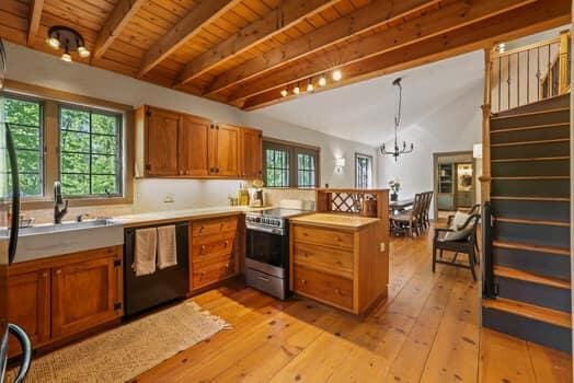 kitchen featuring dishwasher, hanging light fixtures, light hardwood / wood-style floors, stainless steel range oven, and kitchen peninsula