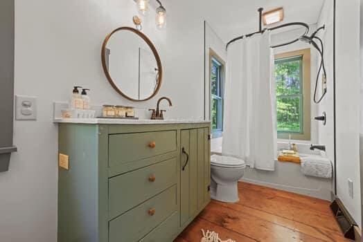 full bathroom featuring shower / tub combo with curtain, vanity, and toilet