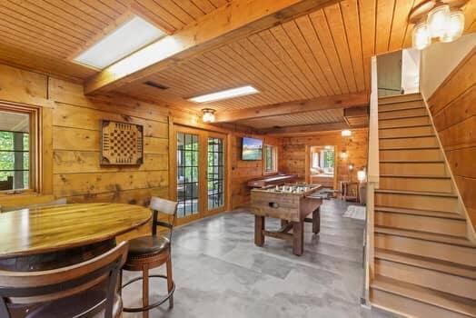 game room with wood walls, french doors, beamed ceiling, and wooden ceiling