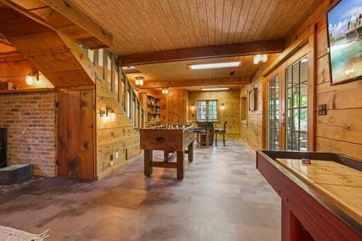 recreation room featuring beamed ceiling, wooden ceiling, and wooden walls