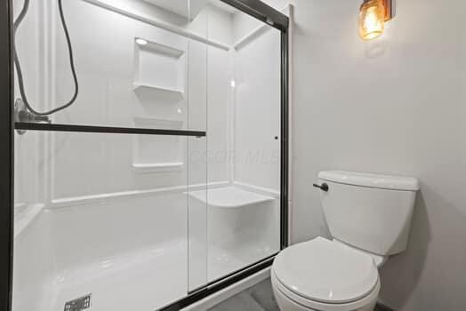 bathroom with toilet and walk in shower