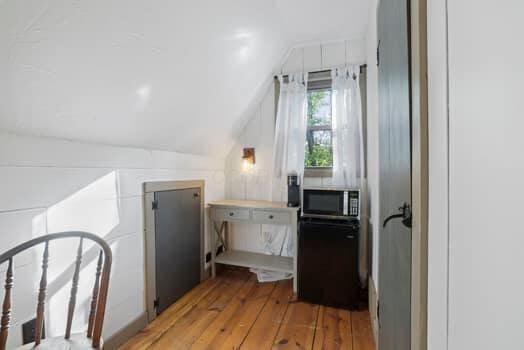 corridor featuring lofted ceiling and light hardwood / wood-style flooring