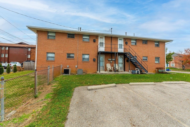 back of property with a patio area, a yard, and central air condition unit