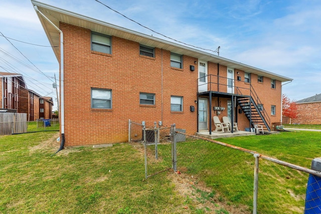 back of property with a yard and a patio area