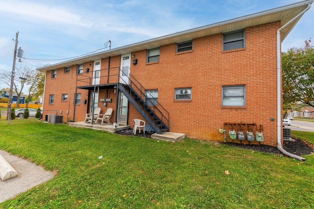 back of property with cooling unit, a yard, and a patio