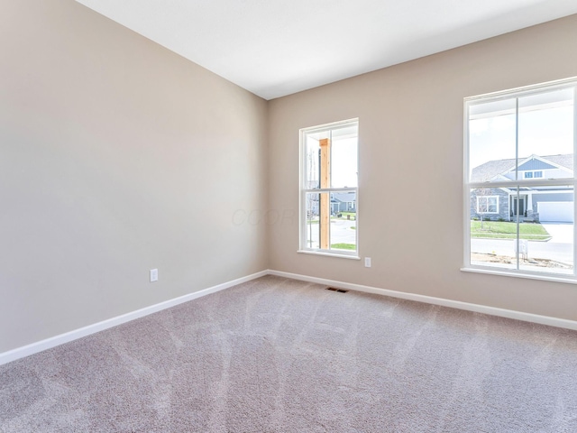 unfurnished room featuring baseboards, carpet flooring, and visible vents