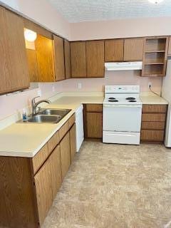 kitchen with a textured ceiling, white appliances, and sink