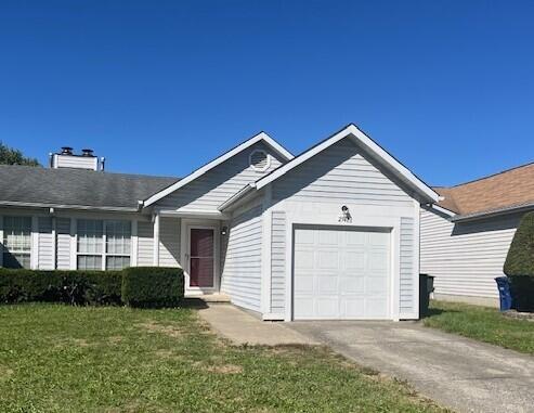 ranch-style house with a front yard and a garage