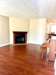 unfurnished living room featuring a textured ceiling and dark hardwood / wood-style floors