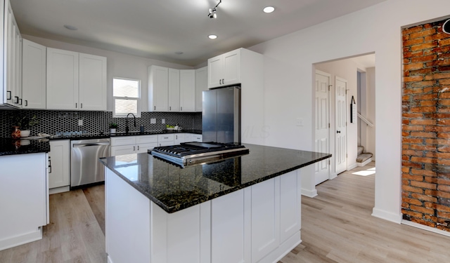 kitchen with white cabinetry, light hardwood / wood-style flooring, a center island, and stainless steel appliances