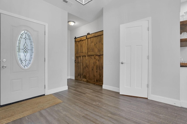 foyer featuring a barn door and wood-type flooring