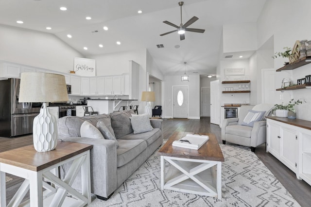 living room with light hardwood / wood-style floors, high vaulted ceiling, and ceiling fan