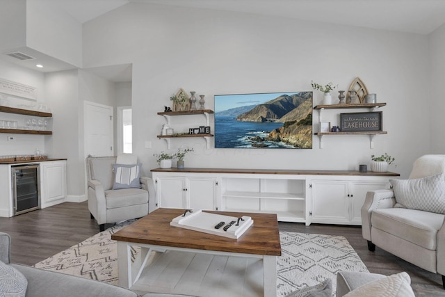 living room featuring high vaulted ceiling, dark hardwood / wood-style flooring, beverage cooler, and indoor bar