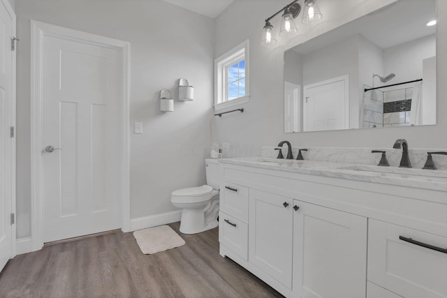 bathroom with a shower, hardwood / wood-style floors, vanity, and toilet