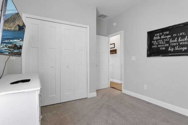 unfurnished bedroom with light carpet and a textured ceiling