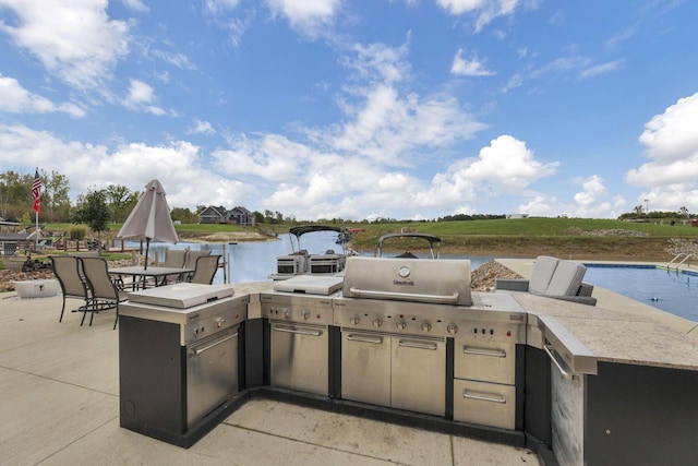 view of patio / terrace with a water view and exterior kitchen