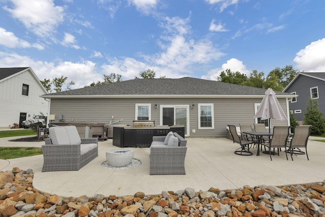 rear view of property with a patio area, an outdoor living space with a fire pit, and a hot tub