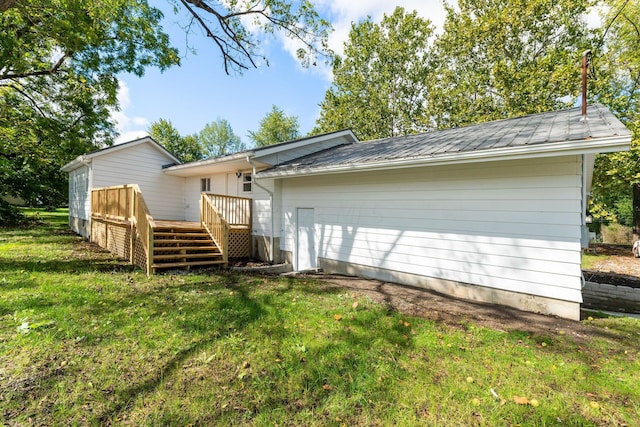 rear view of property with a wooden deck and a yard