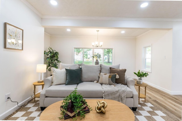 living room featuring crown molding, a chandelier, and light hardwood / wood-style flooring