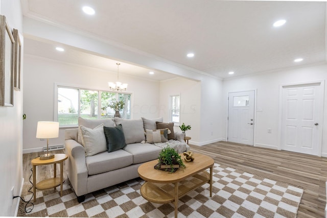 living room featuring crown molding, light hardwood / wood-style flooring, and a chandelier