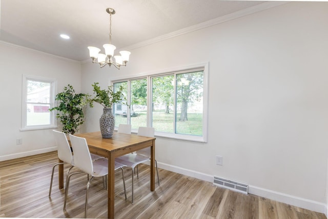 dining room with crown molding, a notable chandelier, and light hardwood / wood-style floors