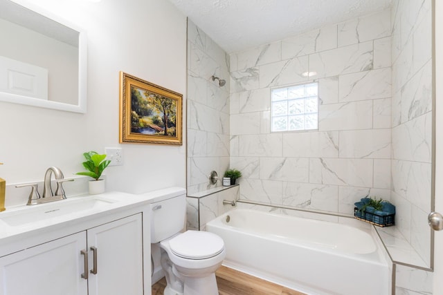 full bathroom with vanity, toilet, tiled shower / bath combo, and a textured ceiling