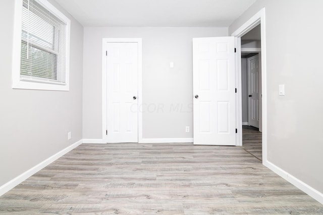 unfurnished bedroom with light hardwood / wood-style floors and a closet