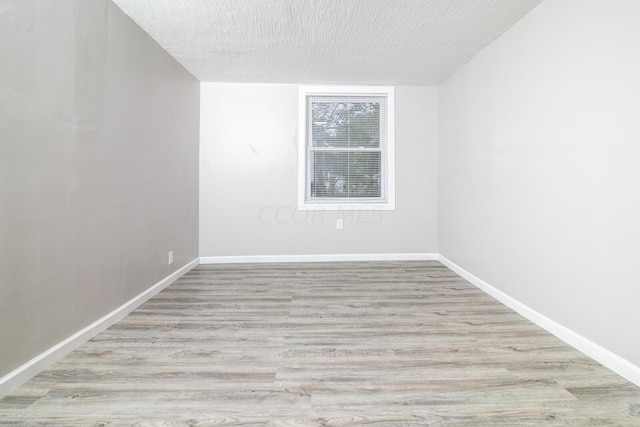 unfurnished room featuring a textured ceiling and light wood-type flooring