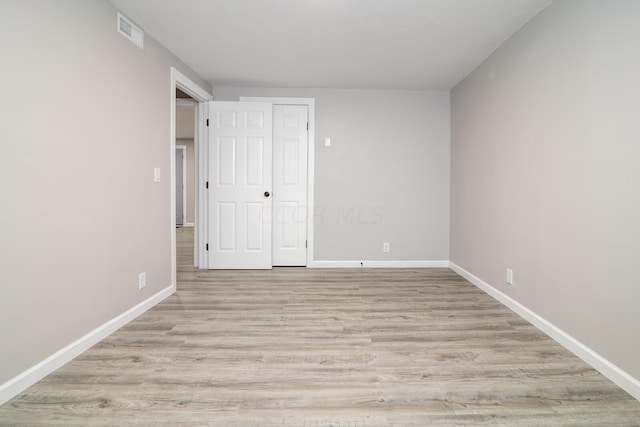 unfurnished bedroom featuring light hardwood / wood-style floors and a closet