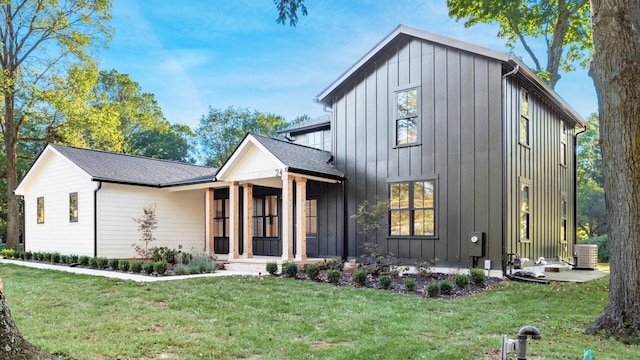 modern farmhouse style home with central air condition unit and a front yard