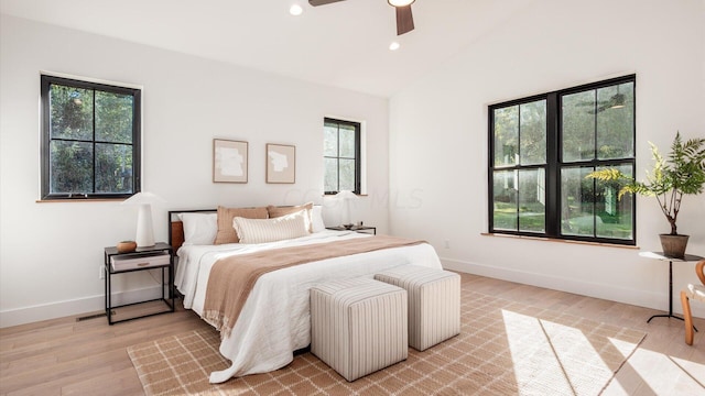 bedroom with ceiling fan, light wood-type flooring, and vaulted ceiling